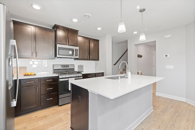 7237 Ada Dr, Lino Lakes, MN 55038 - kitchen featuring stainless steel appliances, light wood-type flooring, backsplash, an island with sink, and recessed lighting