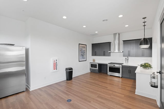 7237 Ada Dr, Lino Lakes, MN 55038 - kitchen with wall chimney exhaust hood, appliances with stainless steel finishes, light countertops, light wood finished floors, and recessed lighting