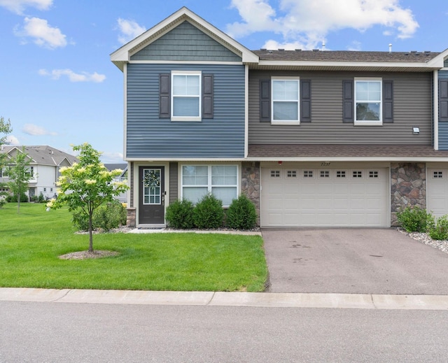 7237 Ada Dr, Lino Lakes, MN 55038 - view of front facade featuring driveway, stone siding, a front lawn, a garage, and a shingled roof