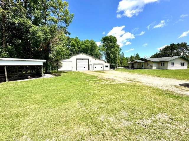 16033 Popplewood Rd NE, Hines Twp, MN 56647 - view of grassy yard with a detached garage, an outbuilding, and dirt driveway