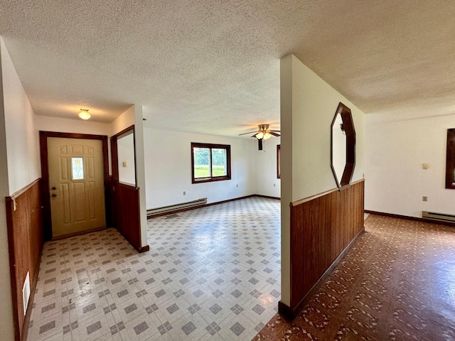 16033 Popplewood Rd NE, Hines Twp, MN 56647 - entrance foyer with a baseboard radiator, ceiling fan, a textured ceiling, light flooring, and wainscoting
