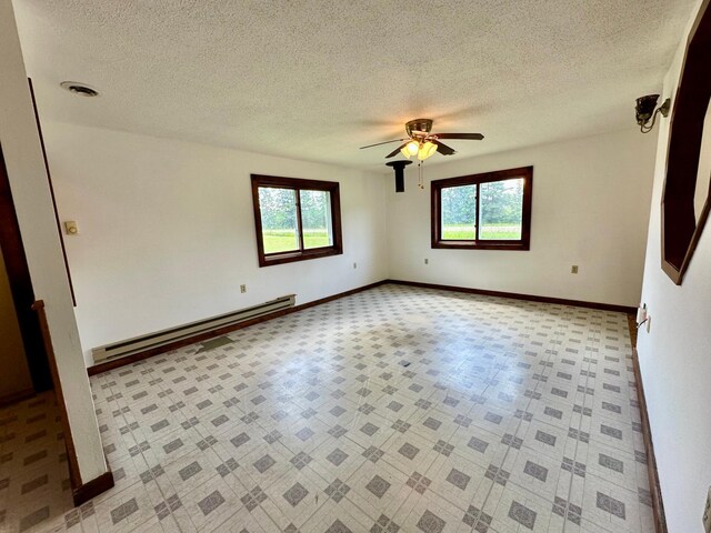 16033 Popplewood Rd NE, Hines Twp, MN 56647 - empty room with a baseboard heating unit, plenty of natural light, a textured ceiling, and ceiling fan