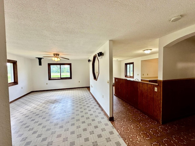 16033 Popplewood Rd NE, Hines Twp, MN 56647 - unfurnished room with a textured ceiling, ceiling fan, tile patterned floors, a smoke detector, and arched walkways