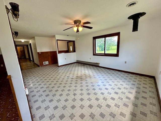 16033 Popplewood Rd NE, Hines Twp, MN 56647 - spare room featuring a baseboard heating unit, a ceiling fan, and a textured ceiling