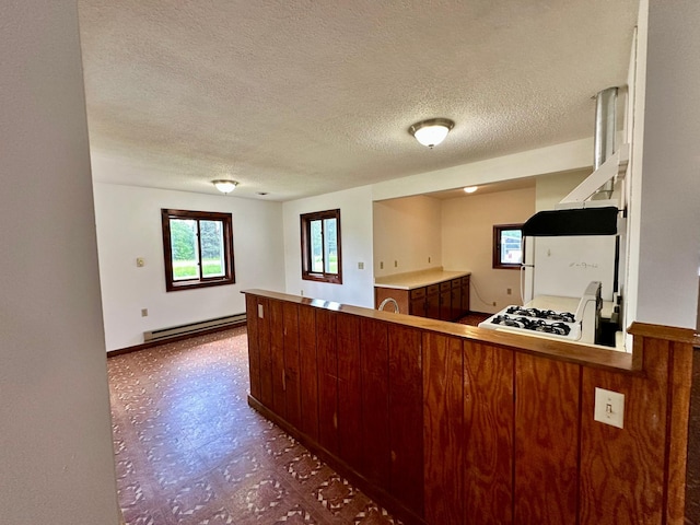 16033 Popplewood Rd NE, Hines Twp, MN 56647 - kitchen with a baseboard heating unit, tile patterned floors, a textured ceiling, and a peninsula