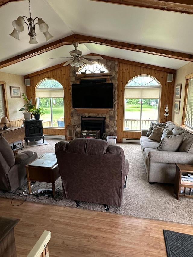 1374 State Highway 11 SE, Baudette, MN 56623 - living room featuring a wood stove, a ceiling fan, light wood-type flooring, wooden walls, and a fireplace