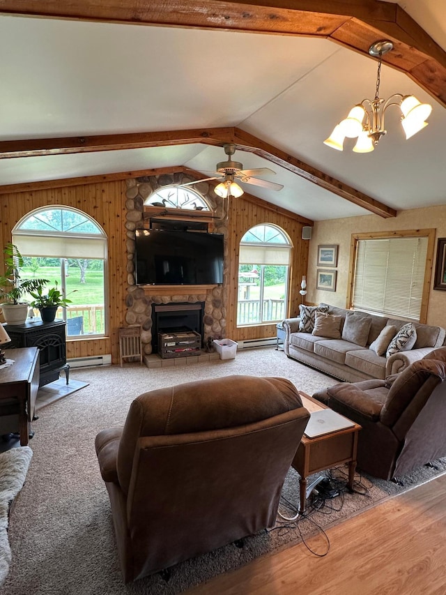 1374 State Highway 11 SE, Baudette, MN 56623 - living room featuring a wood stove, a chandelier, ceiling fan, a baseboard radiator, and a stone fireplace