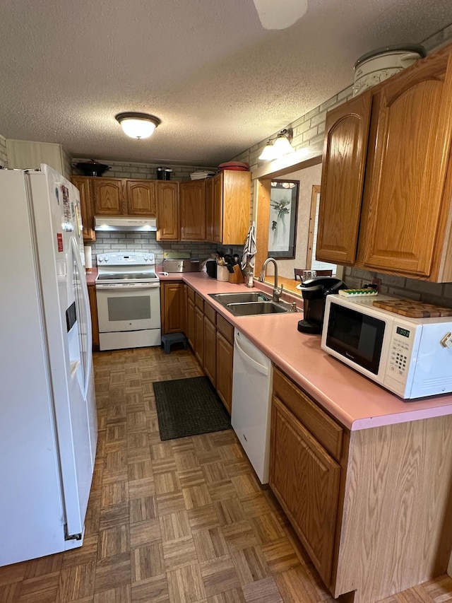 1374 State Highway 11 SE, Baudette, MN 56623 - kitchen featuring white appliances, under cabinet range hood, brown cabinets, light countertops, and a textured ceiling