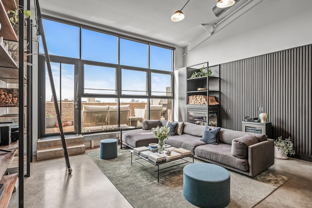 730 Stinson Blvd Unit 504, Minneapolis, MN 55413 - living area featuring finished concrete flooring, healthy amount of natural light, a glass covered fireplace, and a towering ceiling