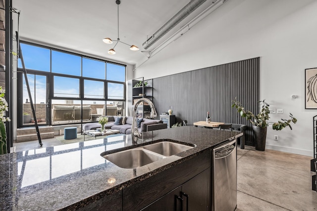 730 Stinson Blvd Unit 504, Minneapolis, MN 55413 - kitchen with stainless steel dishwasher, a towering ceiling, concrete floors, dark stone countertops, and dark brown cabinetry