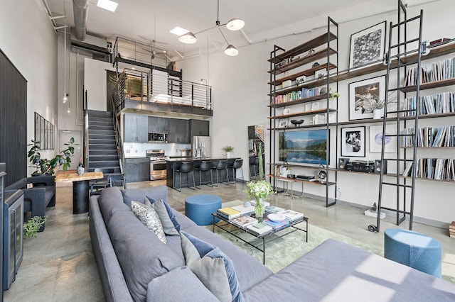 730 Stinson Blvd Unit 504, Minneapolis, MN 55413 - living area featuring a towering ceiling, finished concrete flooring, and stairs
