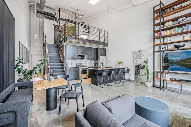730 Stinson Blvd Unit 504, Minneapolis, MN 55413 - living area featuring a towering ceiling, finished concrete flooring, and stairway