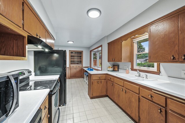 6781 Plaza Curv NE, Fridley, MN 55432 - kitchen with appliances with stainless steel finishes, under cabinet range hood, light countertops, light tile patterned floors, and a peninsula