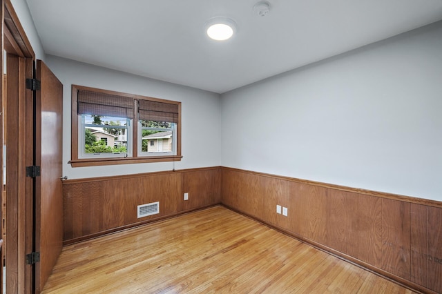 6781 Plaza Curv NE, Fridley, MN 55432 - empty room with a smoke detector, light wood-type flooring, wainscoting, and wooden walls