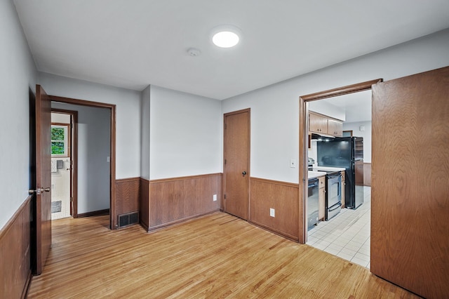 6781 Plaza Curv NE, Fridley, MN 55432 - unfurnished room featuring a wainscoted wall, wood finished floors, a smoke detector, and wooden walls