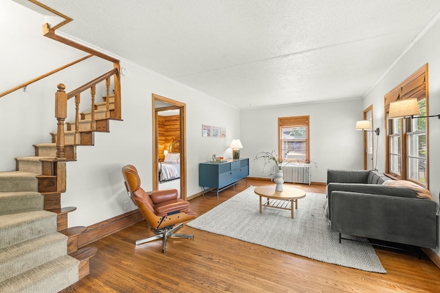 784 Fairview Ave N, Saint Paul, MN 55104 - living room with radiator heating unit, stairway, wood finished floors, crown molding, and a textured ceiling