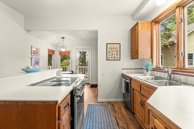 784 Fairview Ave N, Saint Paul, MN 55104 - kitchen with stainless steel appliances, brown cabinets, light countertops, dark wood-type flooring, and hanging light fixtures