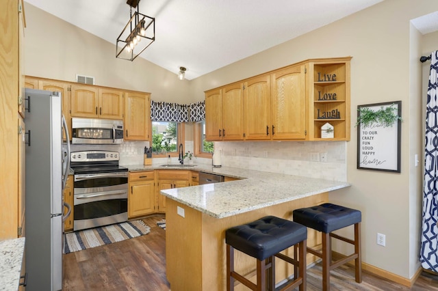2174 Ponds Way, Shakopee, MN 55379 - kitchen with appliances with stainless steel finishes, a peninsula, vaulted ceiling, dark wood-type flooring, and tasteful backsplash