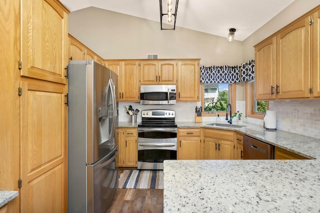 2174 Ponds Way, Shakopee, MN 55379 - kitchen featuring appliances with stainless steel finishes, vaulted ceiling, tasteful backsplash, light stone countertops, and wood finished floors