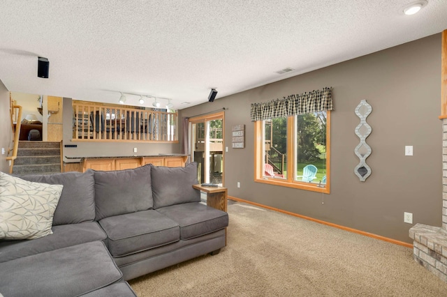 2174 Ponds Way, Shakopee, MN 55379 - living room with light colored carpet, a textured ceiling, and stairs