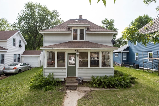 610 2nd St SW, Wadena, MN 56482 - traditional style home with entry steps, roof with shingles, a sunroom, and a front lawn