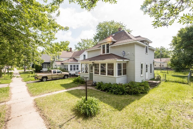 610 2nd St SW, Wadena, MN 56482 - view of front of home featuring roof with shingles, a sunroom, and a chimney