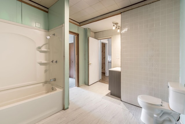610 2nd St SW, Wadena, MN 56482 - bathroom with tile walls, bathing tub / shower combination, and wood finished floors