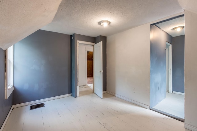 610 2nd St SW, Wadena, MN 56482 - unfurnished bedroom with a textured ceiling, wood finished floors, and lofted ceiling