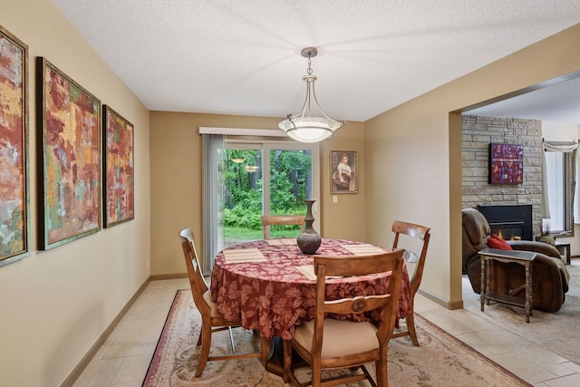 1648 Comstock Ln N, Plymouth, MN 55447 - dining area featuring light tile patterned floors, a fireplace, and a textured ceiling