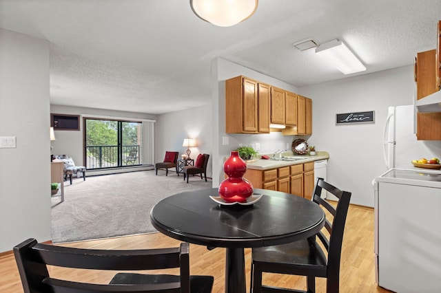 4 Pine Tree Dr Unit 218, Arden Hills, MN 55112 - dining space featuring a textured ceiling, light wood-style flooring, and baseboard heating