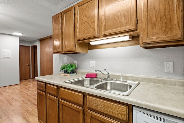 4 Pine Tree Dr Unit 218, Arden Hills, MN 55112 - kitchen featuring white dishwasher, light countertops, light wood-style floors, brown cabinets, and a textured ceiling