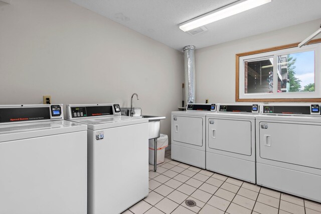 4 Pine Tree Dr Unit 218, Arden Hills, MN 55112 - community laundry featuring washer and dryer and light tile patterned floors