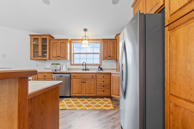 360 Karens Way NW, Alexandria, MN 56308 - kitchen featuring stainless steel appliances, light wood-type flooring, brown cabinets, and light countertops