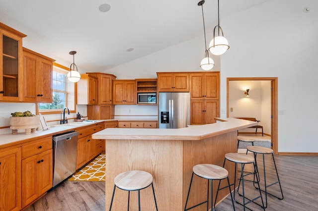 360 Karens Way NW, Alexandria, MN 56308 - kitchen featuring stainless steel appliances, light wood finished floors, a breakfast bar, light countertops, and high vaulted ceiling