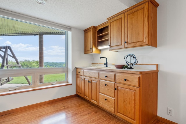 360 Karens Way NW, Alexandria, MN 56308 - kitchen featuring light countertops, plenty of natural light, open shelves, light wood-type flooring, and a textured ceiling