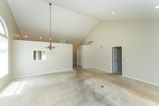 1954 Topaz Pointe Ln SW, Rochester, MN 55902 - unfurnished living room featuring a chandelier, light colored carpet, high vaulted ceiling, and recessed lighting