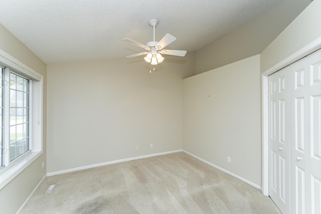 1954 Topaz Pointe Ln SW, Rochester, MN 55902 - unfurnished bedroom with light colored carpet, multiple windows, a closet, a textured ceiling, and a ceiling fan