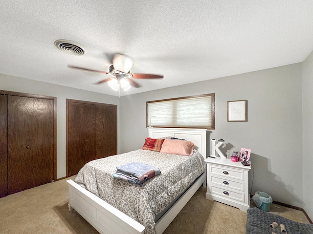 3033 Redwood Ave, Slayton, MN 56172 - bedroom featuring light colored carpet, two closets, a ceiling fan, and a textured ceiling