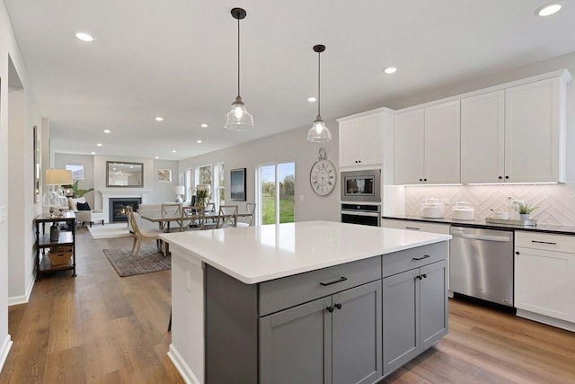 TBB Trinity, Shakopee, MN 55379 - kitchen with appliances with stainless steel finishes, gray cabinets, recessed lighting, tasteful backsplash, and a center island