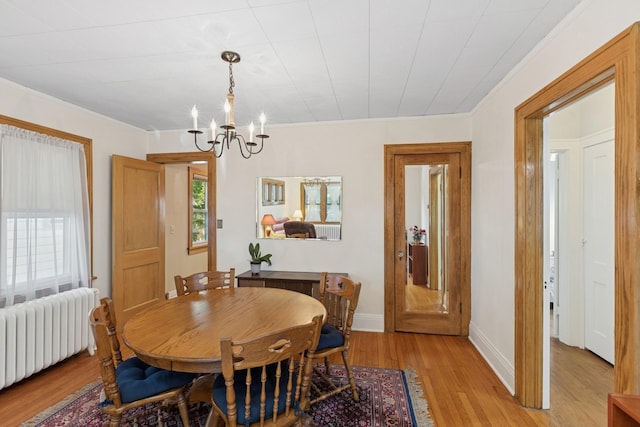 275 Pascal St S, Saint Paul, MN 55105 - dining area with radiator heating unit, a chandelier, light wood-style floors, and ornamental molding