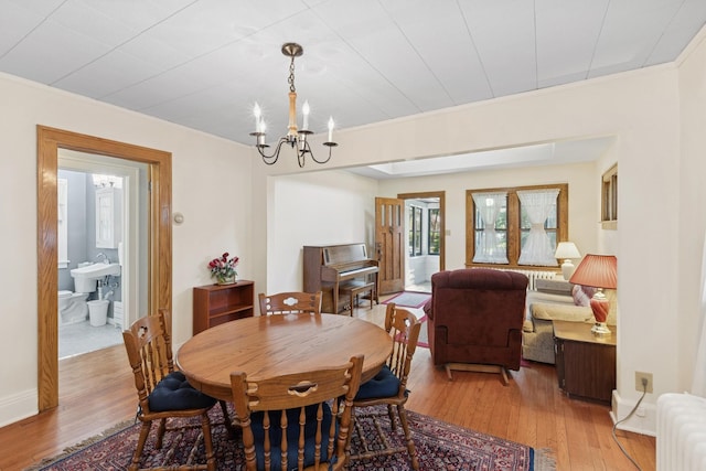 275 Pascal St S, Saint Paul, MN 55105 - dining space featuring radiator heating unit, a chandelier, light wood-style floors, and ornamental molding