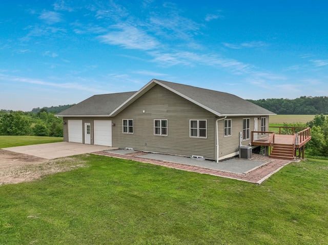 615 18th St, Prairie Lake Twp, WI 54728 - back of house with driveway, a wooden deck, a lawn, and an attached garage