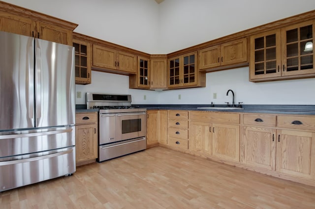 615 18th St, Prairie Lake Twp, WI 54728 - kitchen featuring appliances with stainless steel finishes, dark countertops, light wood finished floors, glass insert cabinets, and brown cabinets