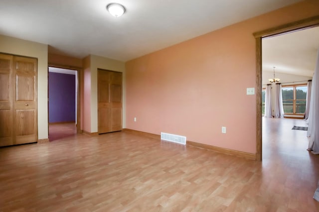615 18th St, Prairie Lake Twp, WI 54728 - spare room with a chandelier, light wood-style flooring, and lofted ceiling