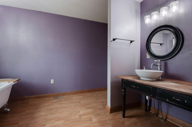 615 18th St, Prairie Lake Twp, WI 54728 - bathroom featuring wood finished floors, vanity, and a freestanding bath