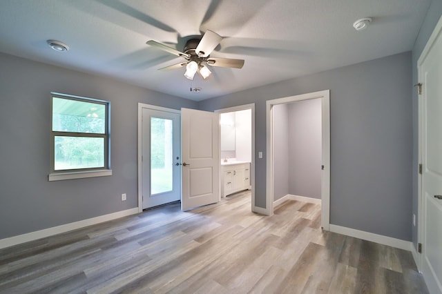 14729 Wildflower Dr, Baxter, MN 56425 - unfurnished bedroom with light wood finished floors, ensuite bath, ceiling fan, and access to outside