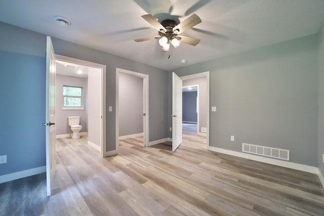 14729 Wildflower Dr, Baxter, MN 56425 - unfurnished bedroom featuring light wood finished floors, ceiling fan, and ensuite bath