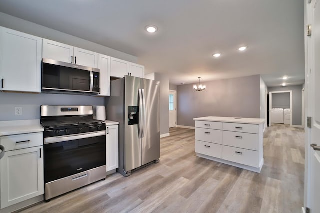 14729 Wildflower Dr, Baxter, MN 56425 - kitchen with appliances with stainless steel finishes, washer and clothes dryer, a chandelier, light countertops, and light wood finished floors