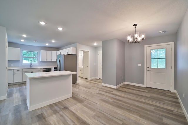 14729 Wildflower Dr, Baxter, MN 56425 - kitchen with appliances with stainless steel finishes, a chandelier, white cabinets, light countertops, and light wood finished floors