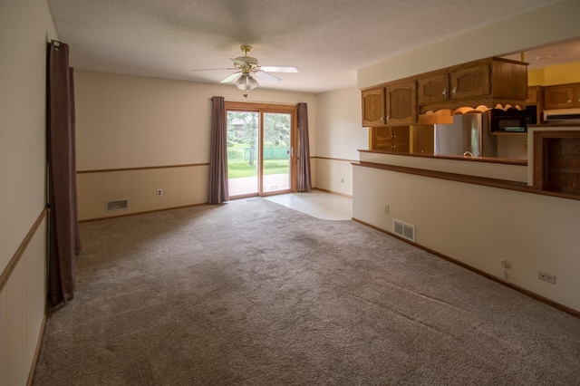 12423 93rd Ave N, Maple Grove, MN 55369 - unfurnished living room with a ceiling fan, light colored carpet, and a textured ceiling